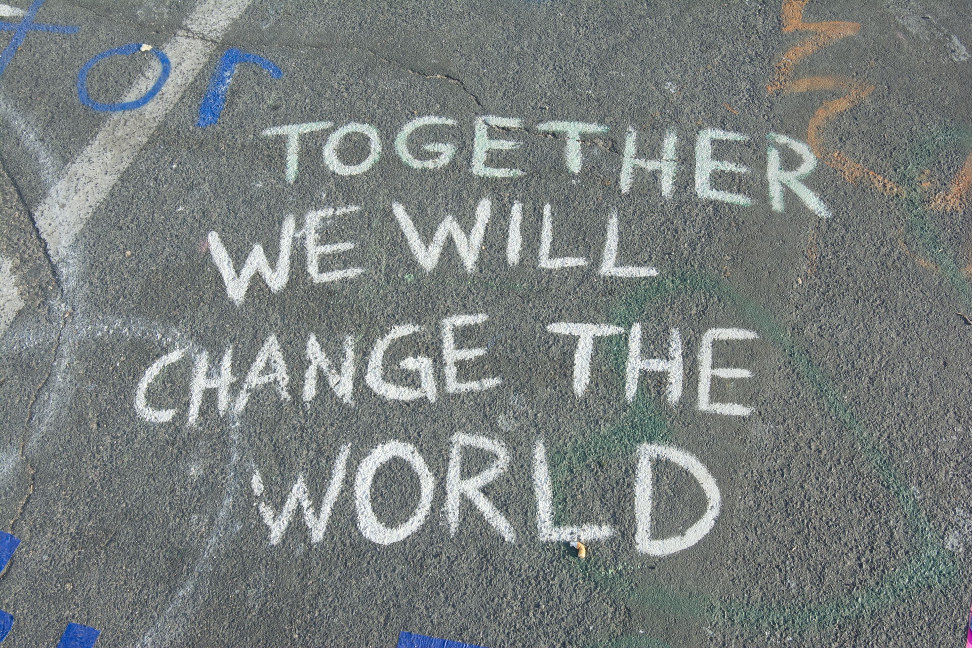 "Together we change the world" written with chalk on a road